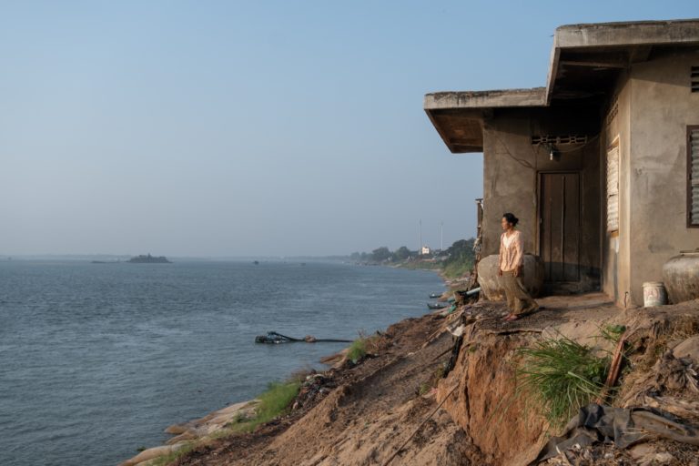 Hak Bopha of Roka Koang commune watches out over the Mekong River where sand mining barges pass by