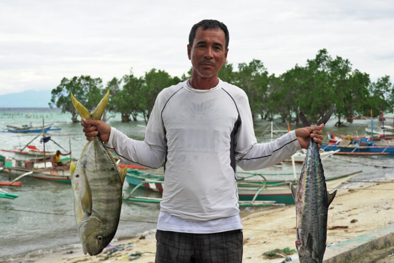 Fisherfolk leader Lorene Gabayeron holding fish.