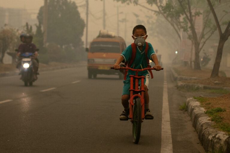 A student goes to school wearing a mask in the haze that blankets the city of Palangka Raya, Central Kalimantan in 2017.