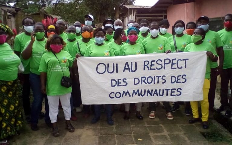 Members of Synaparcam, an association of communities affected by Socapalm holding a banner reading "YES to the respect of community rights" in French. Image courtesy Thierry Didier Kuicheu